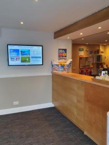 a counter in a store with a tv on the wall at Selborne Hotel in Dunoon