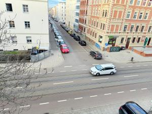 biały samochód jadący ulicą miasta z budynkami w obiekcie Pension Sonnenschein w mieście Halle (Saale)