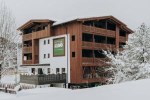 a large building with a sign in the snow at Garni Residence Alnö - Adults Only in San Vigilio Di Marebbe