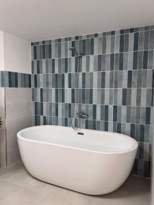baño con bañera blanca y azulejos en MariMuntagna, en Catania