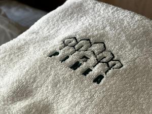 a white towel with the wordarma written on it at Pinea b&b in Castellaneta Marina 