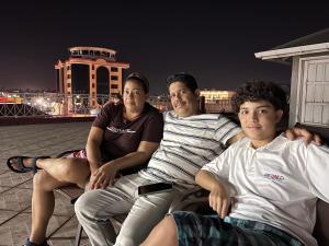 a group of three people sitting on a balcony at night at Emerald Apartments INC in Georgetown