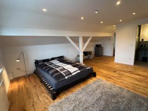 um quarto com uma cama num piso de madeira em Harkort Seeblick 1 em Herdecke