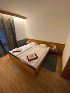 a bedroom with a large bed with two red folders at Marina Alpen Haus in Zell am See