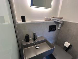 a bathroom with a sink and a mirror and towels at Harkort Seeblick 1 in Herdecke