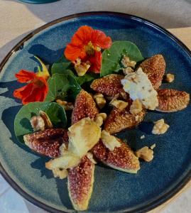a blue plate of food with a flower on it at Au Pré Fleuri Eco Glamping in Le Lindois +25 photos
