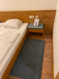 a bed with a nightstand next to a bed with a table at Marina Alpen Haus in Zell am See