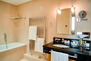 a bathroom with a sink and a tub and a mirror at Oakley Hall Hotel in Basingstoke