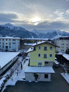 a view of a city with snow covered buildings and mountains at Marina Alpen Haus in Zell am See