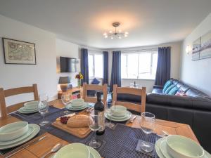 a living room with a table and a dining room at Tradewinds Gwbert in Towyn