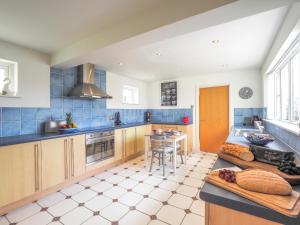 a kitchen with blue tiled counters and a table at Tradewinds Gwbert in Towyn