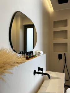 a bathroom with a sink and a mirror at On The Rocks Villas Ios in Ios Chora