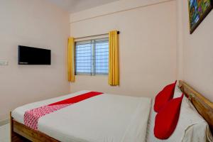 Dormitorio pequeño con cama y TV en OYO Flagship Hotel VBH Inn en Kammasandra
