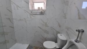 une salle de bain blanche avec toilettes et fenêtre dans l'établissement Happen!ng, à Faro 99 autres photos