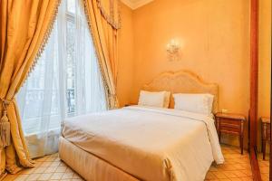 a bedroom with a bed and a large window at Napoleon Suite Champs Elysees in Paris