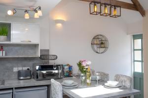 a kitchen with a table with chairs and a microwave at The Dairy Newport, Pembrokeshire in Newport Pembrokeshire