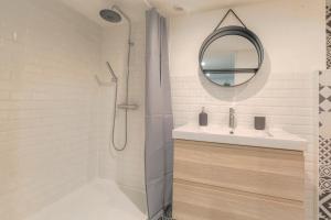 uma casa de banho com um chuveiro, um lavatório e um espelho. em Duplex Design proche Part-Dieu em Villeurbanne