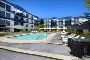 a swimming pool in front of a apartment building at Marina Magic: Seaside Sanctuary With Marina Views! in Los Angeles