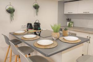 uma cozinha com uma mesa com pratos e cadeiras em Duplex Design proche Part-Dieu em Villeurbanne
