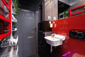 baño con lavabo y pared roja en Lux Studio City Center Sołtyka by Renters, en Cracovia
