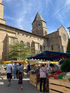 un gruppo di persone in un mercato all'aperto di fronte a una chiesa di Au Pré Fleuri Eco Glamping a Le Lindois