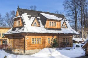 a log cabin with snow on the roof at U Nas Pokoje Goscinne in Zakopane