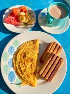 two plates of breakfast food and a cup of coffee at Hotel Anauco in Bucaramanga