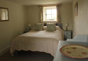 a bedroom with a bed and a window and a table at Dee's Cottage at Brinsop in Hereford