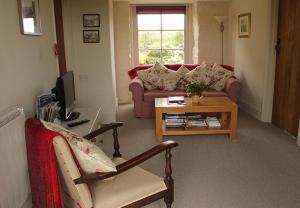 a living room with a couch and a table at Dee's Cottage at Brinsop in Hereford