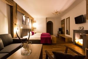 a hotel room with a bed and a living room at Verwöhn-Harmoniehotel Mandarfnerhof in Sankt Leonhard im Pitztal