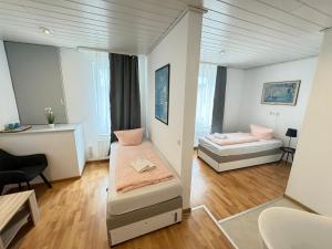 mały pokój z dwoma łóżkami i kanapą w obiekcie Pension Sonnenschein w mieście Halle (Saale)