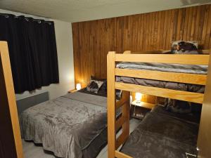 sypialnia z 2 łóżkami piętrowymi w pokoju w obiekcie Appartement Spacieux Pra Loup T4 11 pers. 105m² w mieście Uvernet