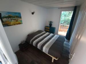 een slaapkamer met een bed in een kamer met een raam bij Gîtes de la Gare - Les conteneurs in Plessé