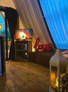 a living room with a tv in a tent at A-luxury Glamping by La Mignola in Fasano