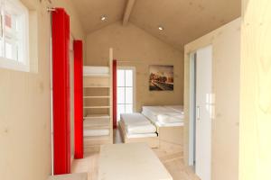 a room with bunk beds and a red door at Ravensburger Spieleland Feriendorf in Meckenbeuren