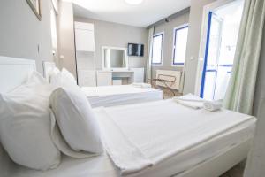 twee bedden in een kamer met witte lakens bij Sunpoint Hotel Bodrum in Bodrum City +67 foto's