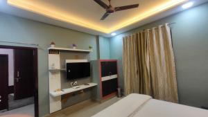 a bedroom with a bed and a tv on the wall at Hotel the sirsa inn in Sirsa