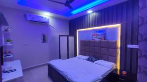 a bedroom with a bed with a blue light at Hotel the sirsa inn in Sirsa