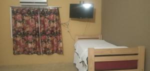 mały pokój z łóżkiem i telewizorem w obiekcie Inti Mayu w mieście Villa Cura Brochero