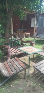 a picnic table and a bench next to a tree at Inti Mayu in Villa Cura Brochero