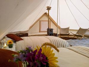 a tent with two beds and a table with flowers at Cavalan Ranch 