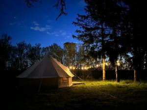 a white tent in a field at night at Cavalan Ranch in Wardow +12 photos