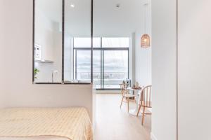 Cet appartement comprend une chambre avec un lit et une cuisine avec une table. dans l'établissement Les Appartements de Grenoble, à Grenoble