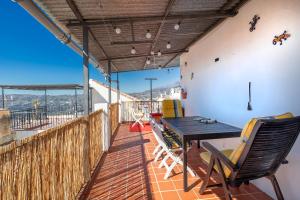 a patio with a table and chairs on a balcony at Casa Marlo, Spacious House in the Lively Centre of Cómpeta in Cómpeta