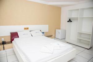 um quarto com uma grande cama branca num quarto em Trip Hotel Lauro de Freitas em Lauro de Freitas