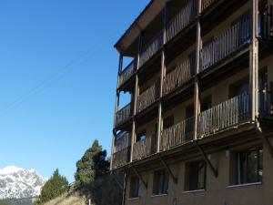 ein Gebäude mit Balkonen und einem Berg im Hintergrund in der Unterkunft Ideal per una escapada in Bordes d´Envalira 