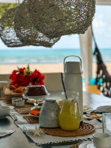 a table with a glass jug of orange juice on it at Beach Houses Moitas in Amontada