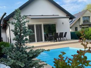 a house with a swimming pool in front of a house at RoyalHill Apartman in Vonyarcvashegy