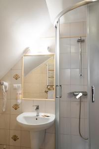 y baño con lavabo y ducha con espejo. en Hotel Restauracja Browar Lwów w Lublinie, en Lublin