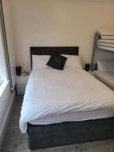 ein Schlafzimmer mit einem großen Bett mit weißer Bettwäsche und Kissen in der Unterkunft QUICK STOP-GATWICK STAY, Family Room-GR1 in Ifield
